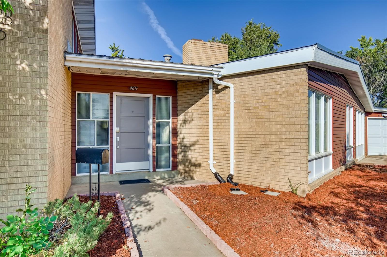 4611 Pierce Street Wheat Ridge, CO 80033 - Photo 1 of 30 a front view of a house with garden
