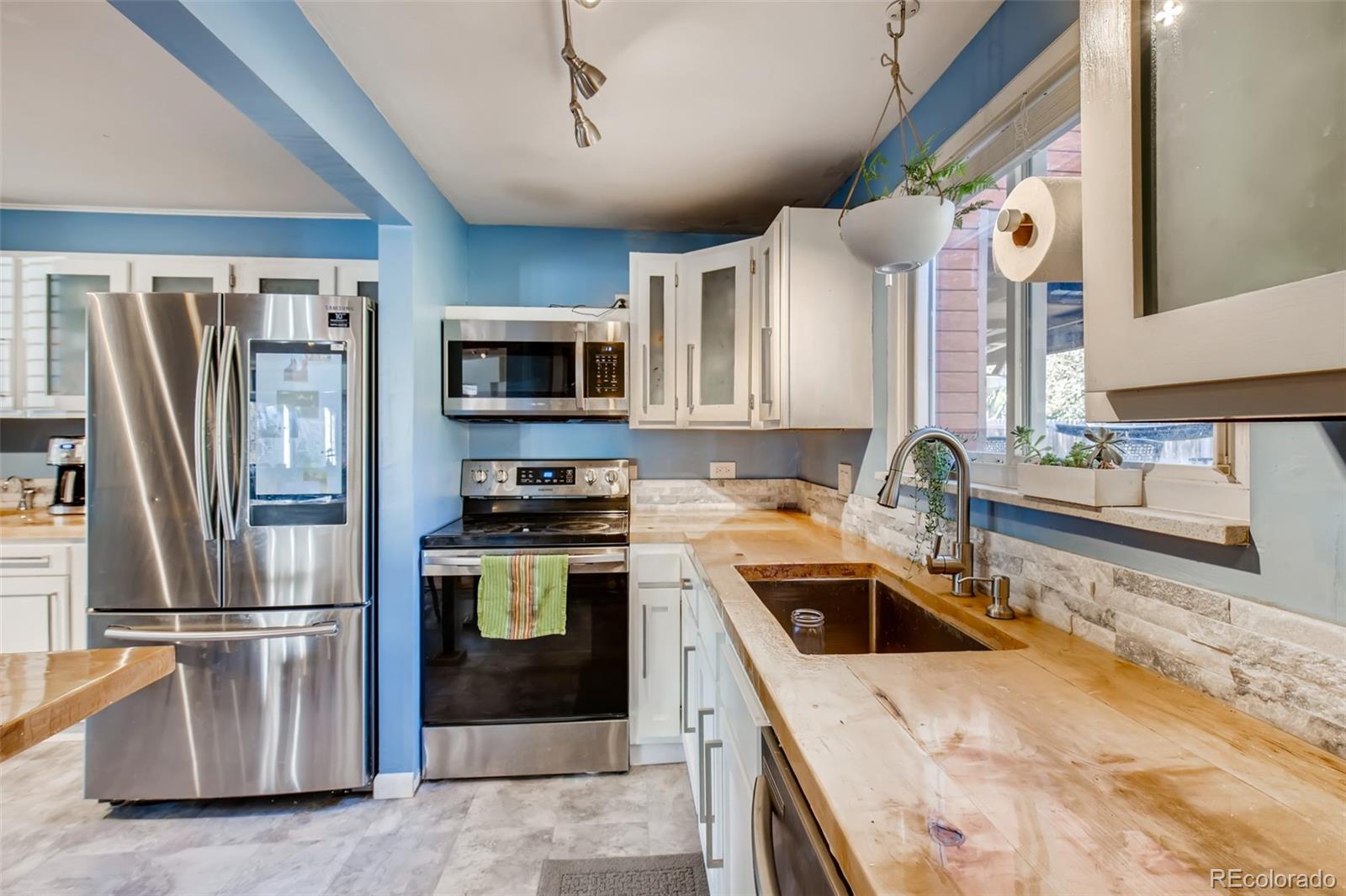 4611 Pierce Street Wheat Ridge, CO 80033 - Photo 13 of 30 a kitchen that has a sink cabinets counter space stainless steel appliances