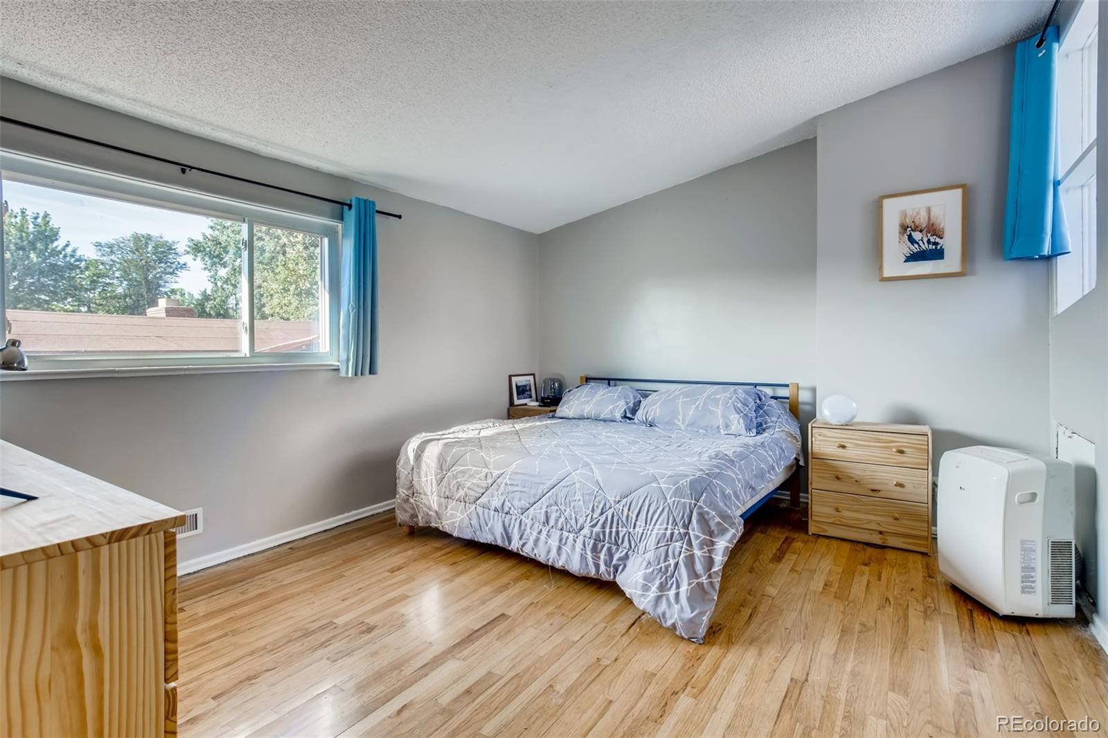4611 Pierce Street Wheat Ridge, CO 80033 - Photo 15 of 30 a bedroom with a bed and wooden floor