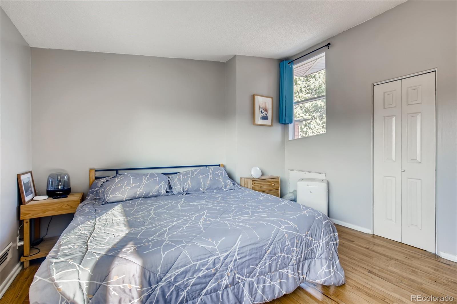 4611 Pierce Street Wheat Ridge, CO 80033 - Photo 16 of 30 a bedroom with a bed and wooden floor