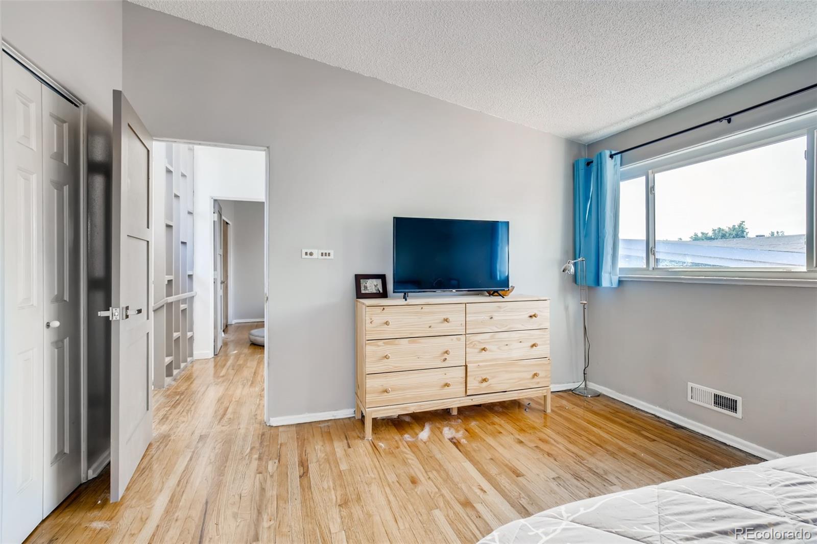 4611 Pierce Street Wheat Ridge, CO 80033 - Photo 17 of 30 a room with a bed and a flat screen tv