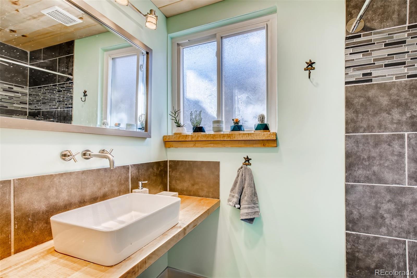 4611 Pierce Street Wheat Ridge, CO 80033 - Photo 23 of 30 a bathroom with a sink and a mirror