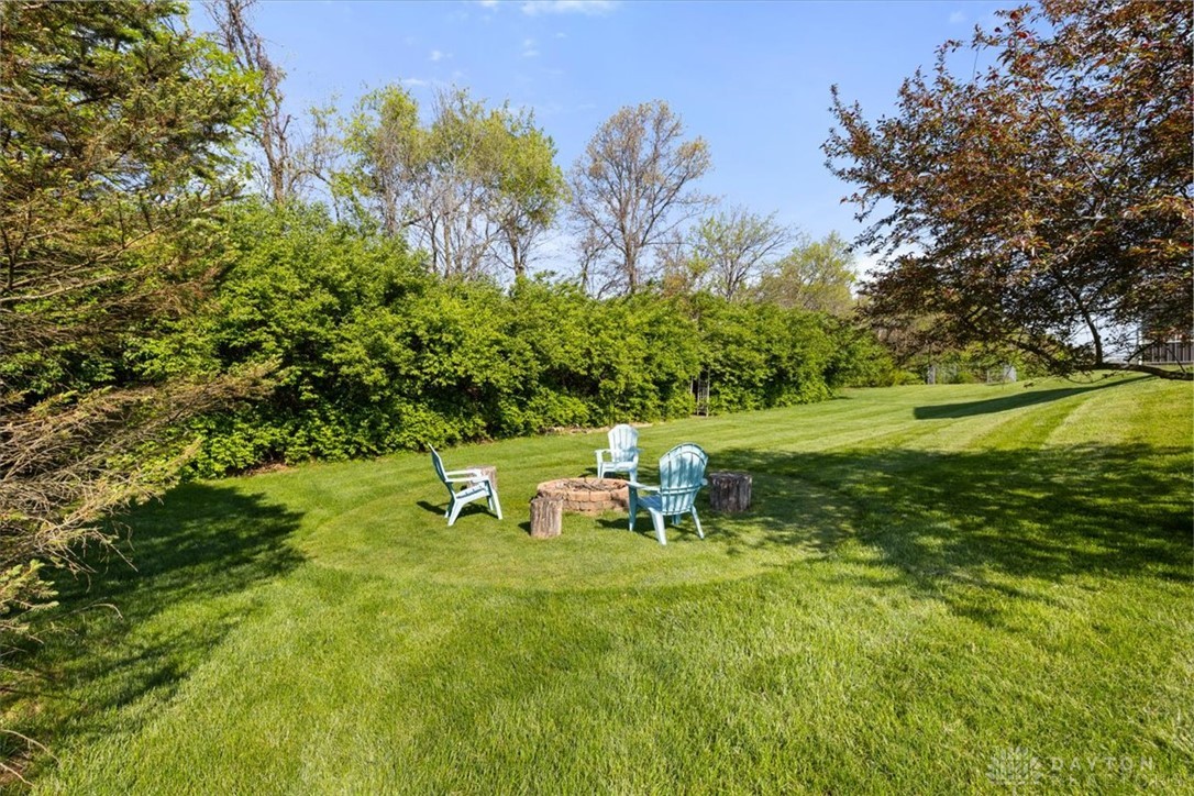 841 Willow Road Springfield, OH 45502 - Photo 45 of 64 This lush yard features a dedicated fire pit area, perfect for gatherings under the open sky.