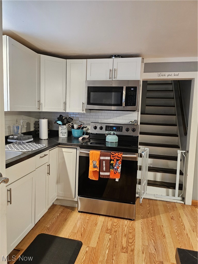 19714 Drake Road Strongsville, OH 44149 - Photo 17 of 32 Kitchen with white cabinets, backsplash, light hardwood floors, and stainless steel electric range oven