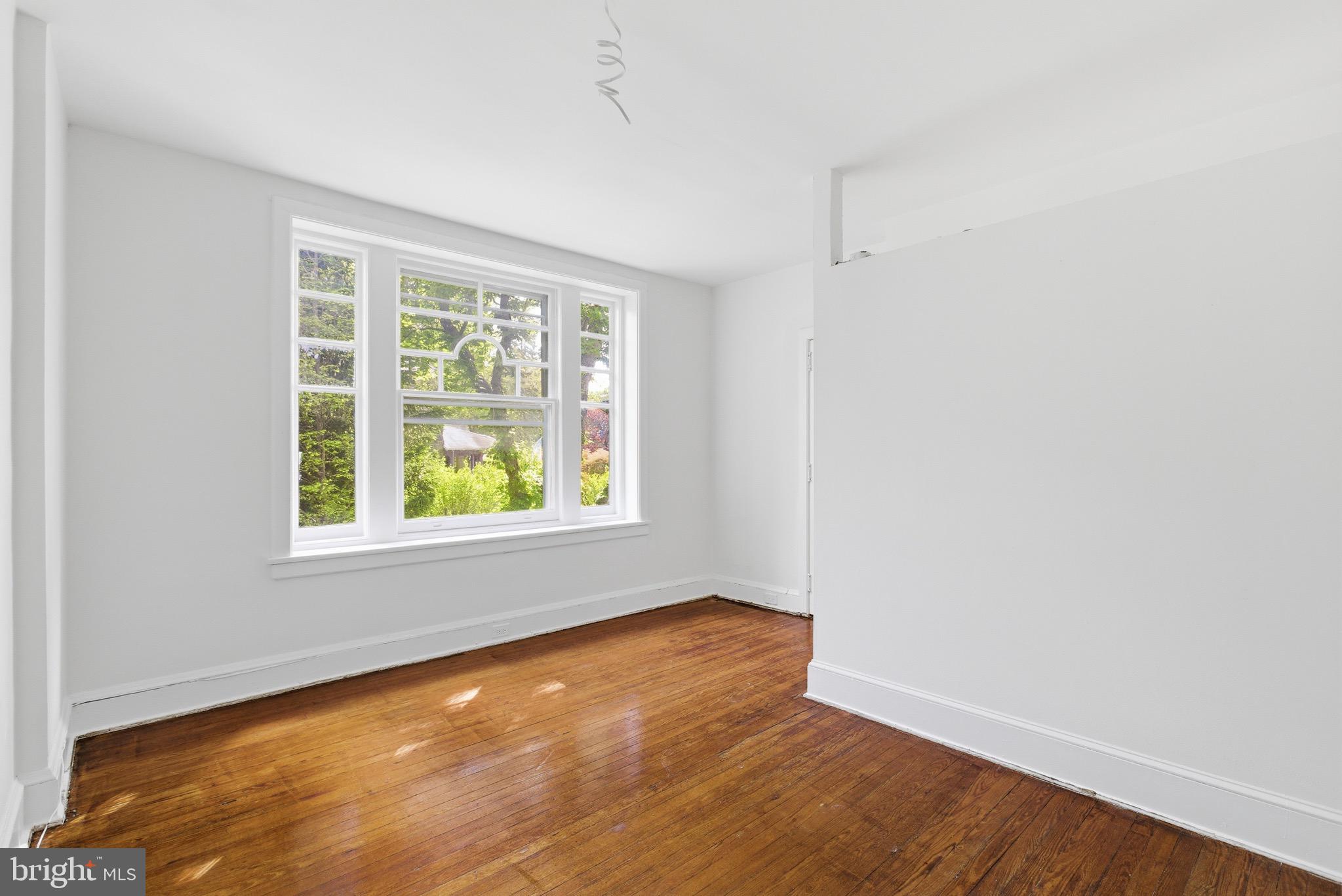 5939 Drexel Road, Unit 2 Philadelphia, PA 19131 - Photo 6 of 17 an empty room with wooden floor and windows