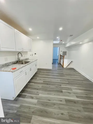 a large white kitchen with kitchen island a sink stainless steel appliances and cabinets