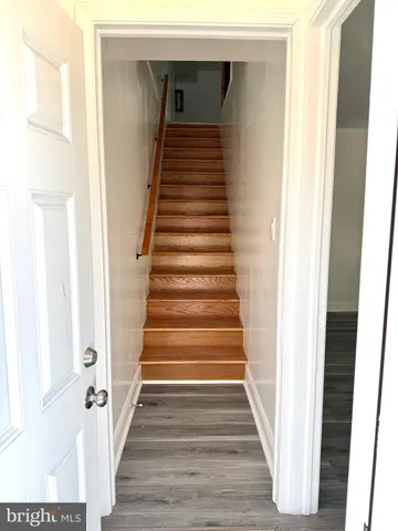 a view of a hallway with wooden floor and entryway