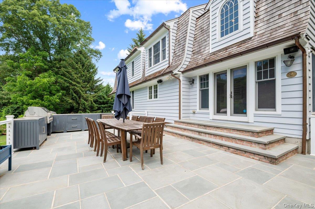 5 Fox Hunt Court Cold Spring Harbor, NY 11724 - Photo 33 of 42 Expansive stone patio featuring an outdoor kitchen with integrated grill and cabinetry