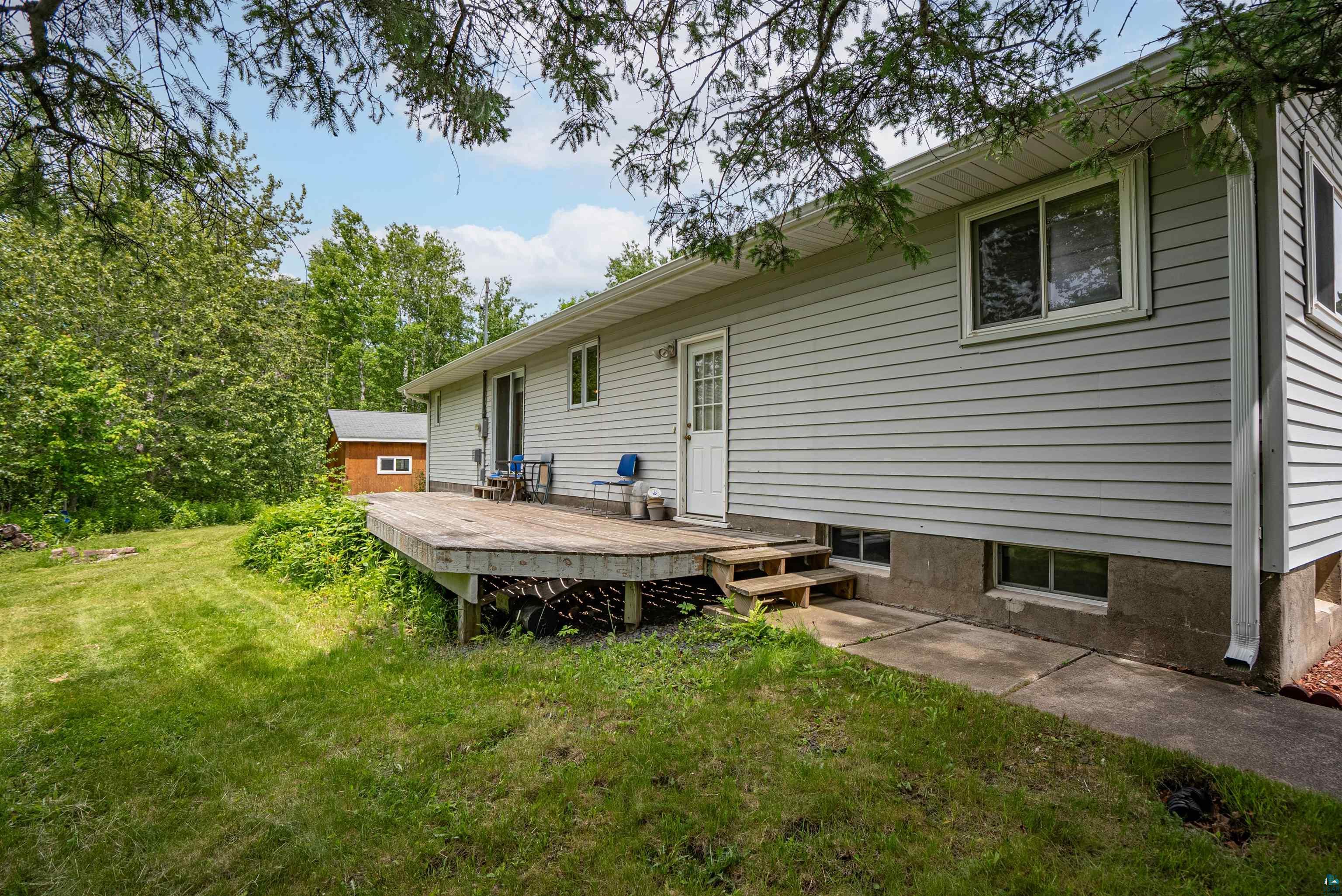 3711 Getchell Road Hermantown, MN 55811 - Photo 24 of 31 Rear exterior featuring a spacious wood deck, light gray horizontal siding, and a white entry door