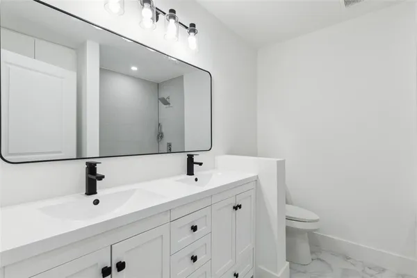 a bathroom with a sink a toilet and a mirror