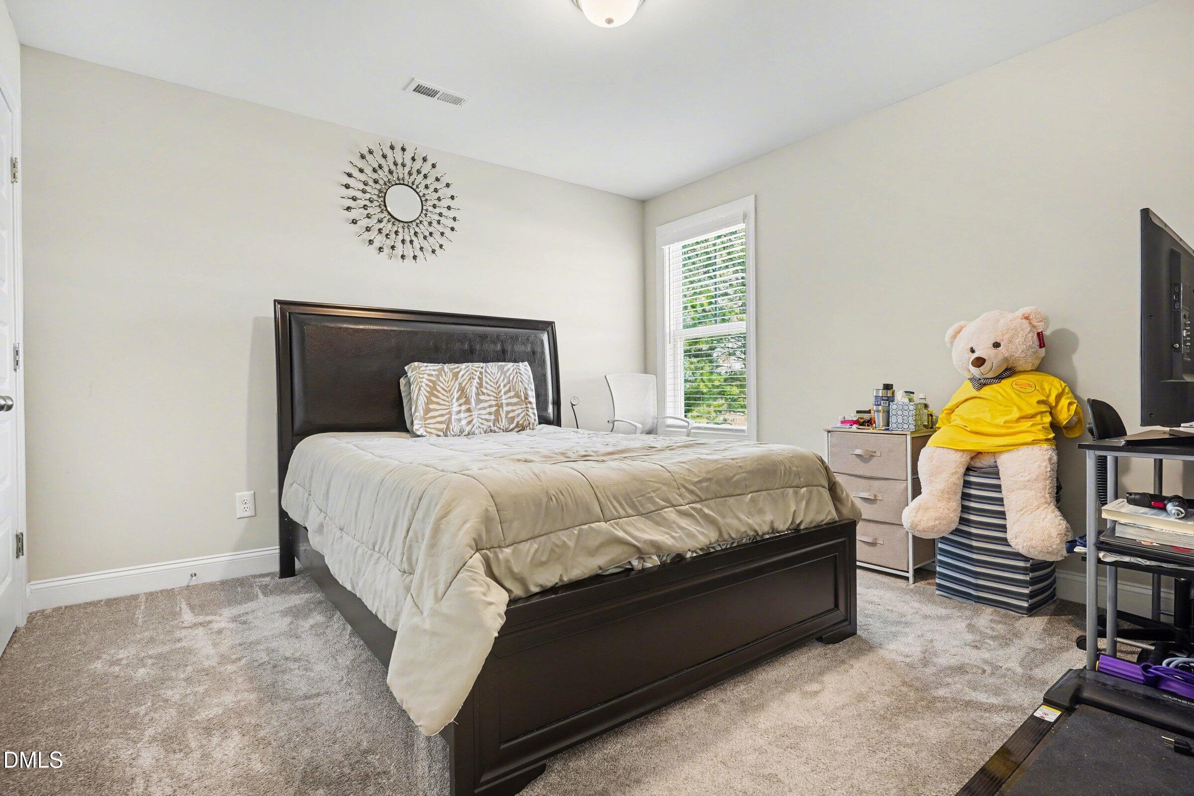 10 Mitchell Rdg Drive Youngsville, NC 27596 - Photo 22 of 38 a spacious bedroom with a bed table chair and a window