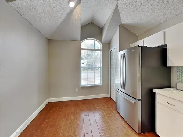 a kitchen with a refrigerator and wooden floor