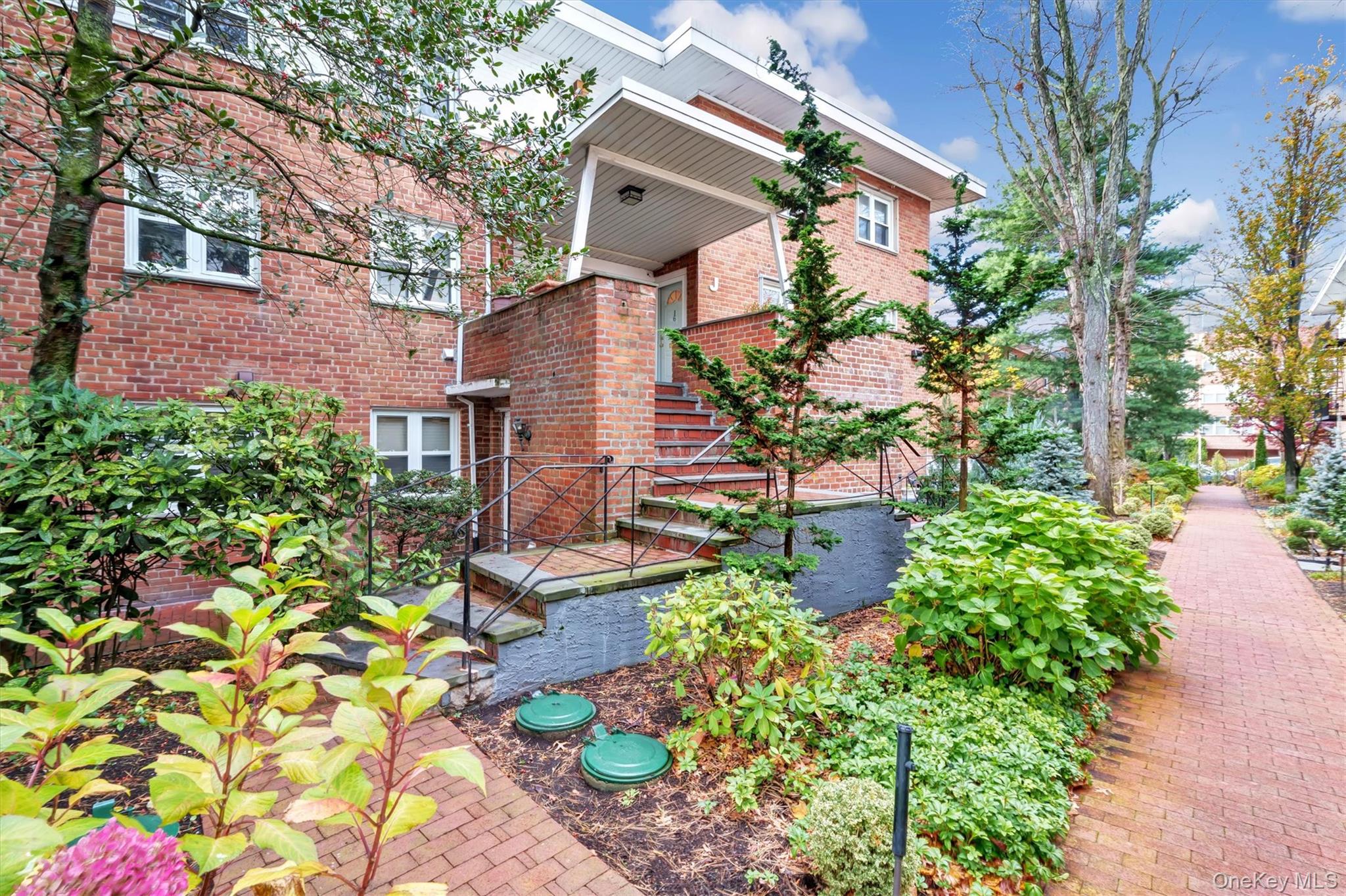 200 South Middle Neck Road, Unit J6 Great Neck, NY 11021 - Photo 2 of 22 a front view of a house with a yard and garden