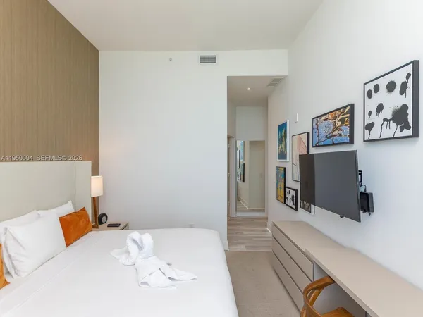 a bedroom with a bed and a flat screen tv