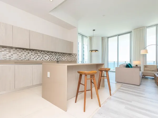 a kitchen with granite countertop a table chairs sink and cabinets