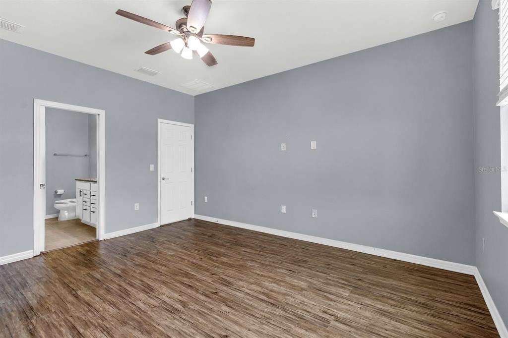 12653 Palapa Loop Spring Hill, FL 34610 - Photo 11 of 33 an empty room with wooden floor and a ceiling fan