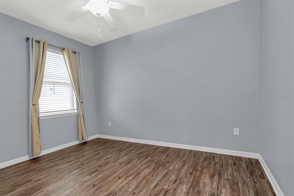 12653 Palapa Loop Spring Hill, FL 34610 - Photo 13 of 33 an empty room with wooden floor and windows