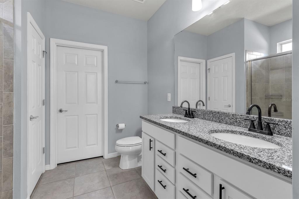 12653 Palapa Loop Spring Hill, FL 34610 - Photo 20 of 33 a bathroom with a granite countertop sink and a mirror