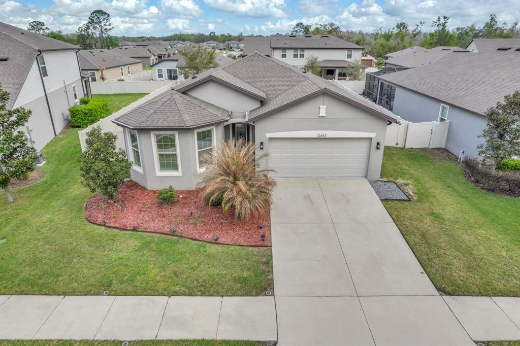 12653 Palapa Loop Spring Hill, FL 34610 - Photo 2 of 33 a aerial view of a house with a yard and potted plants