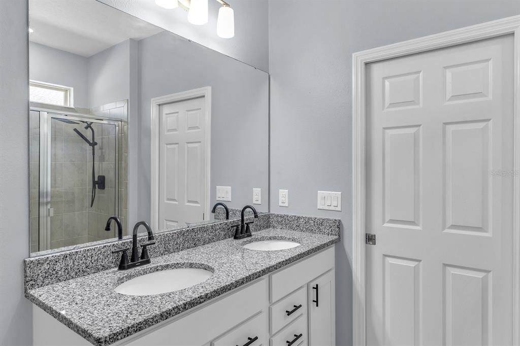 12653 Palapa Loop Spring Hill, FL 34610 - Photo 21 of 33 a bathroom with a granite countertop sink and a mirror