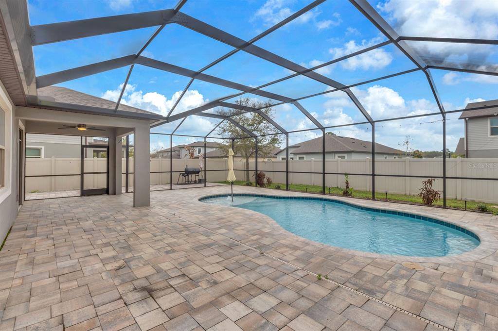 12653 Palapa Loop Spring Hill, FL 34610 - Photo 28 of 33 a view of a backyard of a house with pool and garage