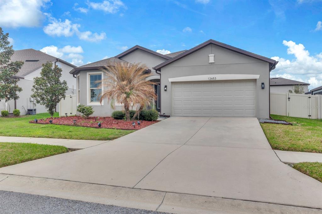 12653 Palapa Loop Spring Hill, FL 34610 - Photo 32 of 33 a front view of a house with a yard and garage