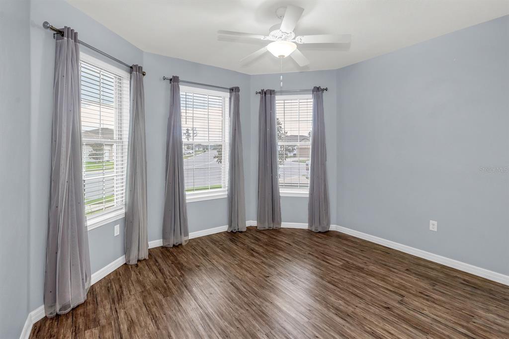 12653 Palapa Loop Spring Hill, FL 34610 - Photo 9 of 33 an empty room with wooden floor fan and windows