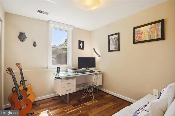 a bedroom with a bed and a painting on the wall