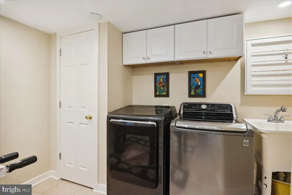 a living room with stainless steel appliances furniture a rug and a kitchen view