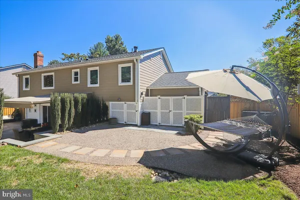 a view of a patio with couches table and chairs with wooden fence and plants