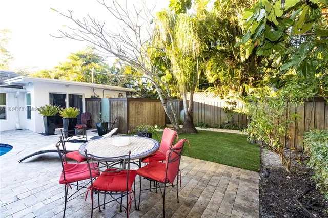 a view of a table and chairs in back yard of the house