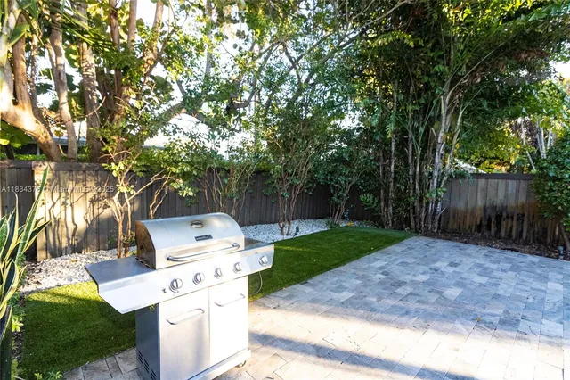 a view of backyard with wooden fence and a large trees