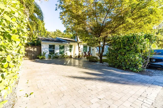 a view of a yard with plants and trees