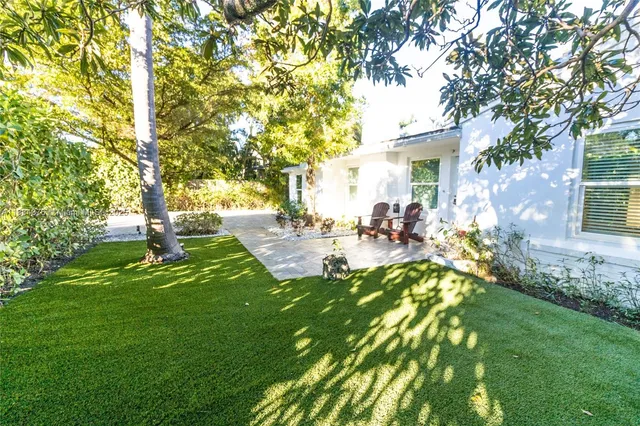 a view of a yard with plants and trees