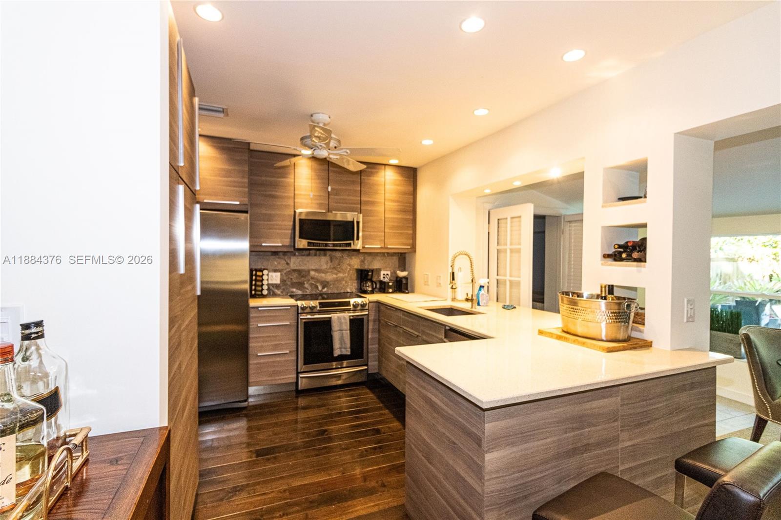 744 Northeast 16th Avenue Fort Lauderdale, FL 33304 - Photo 6 of 26 a kitchen with a refrigerator a stove and a microwave oven with cabinets