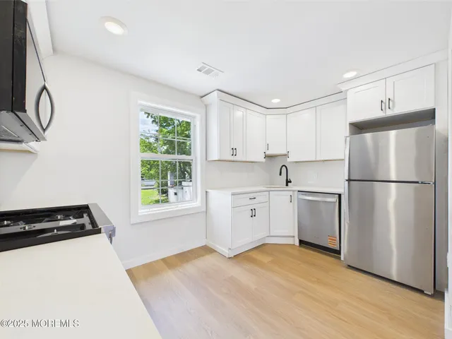 a kitchen with a stove a sink and a microwave