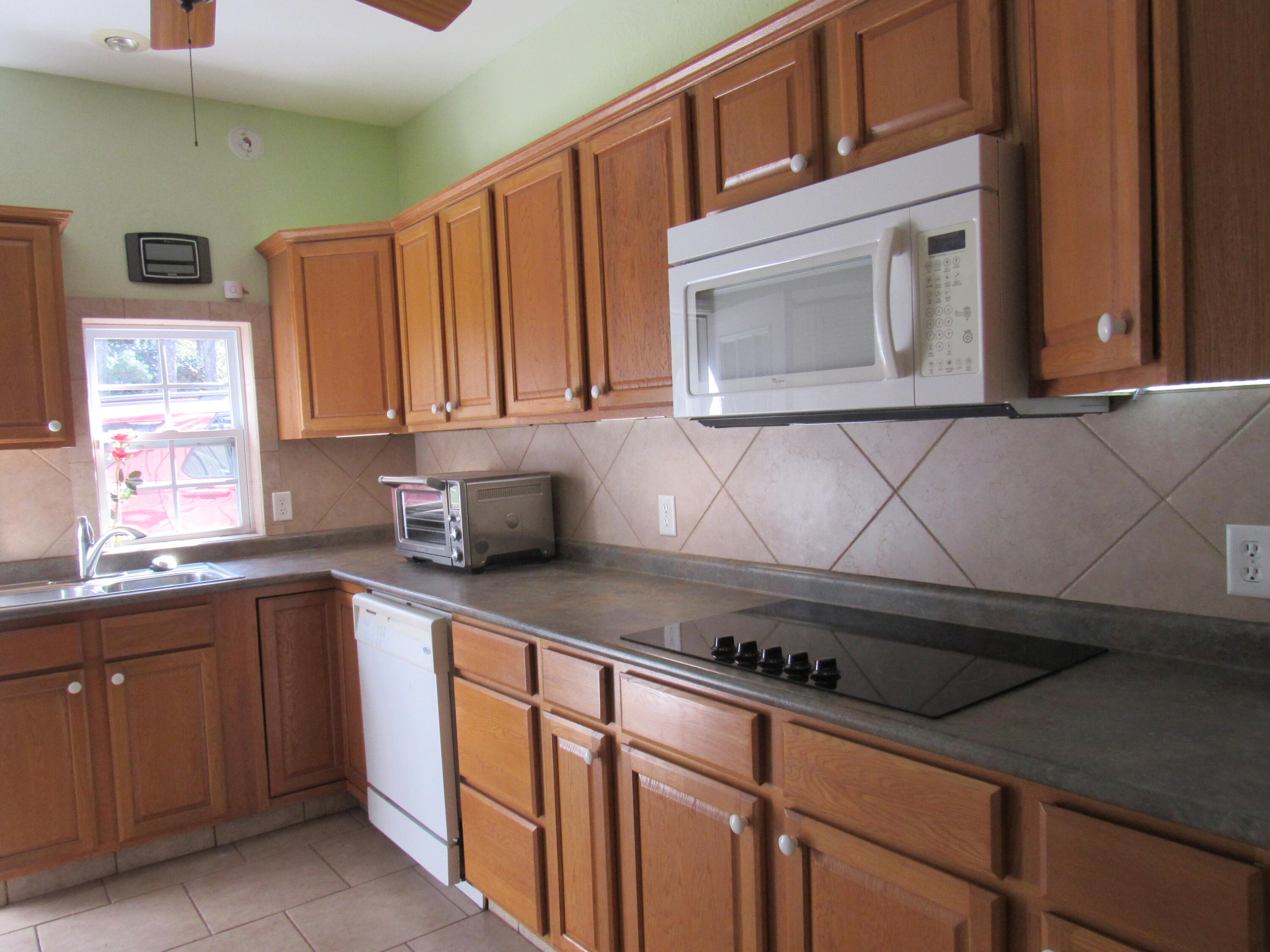 82 Palmetto Street Freeport, FL 32439 - Photo 37 of 55 a kitchen with stainless steel appliances a sink dishwasher stove and cabinets