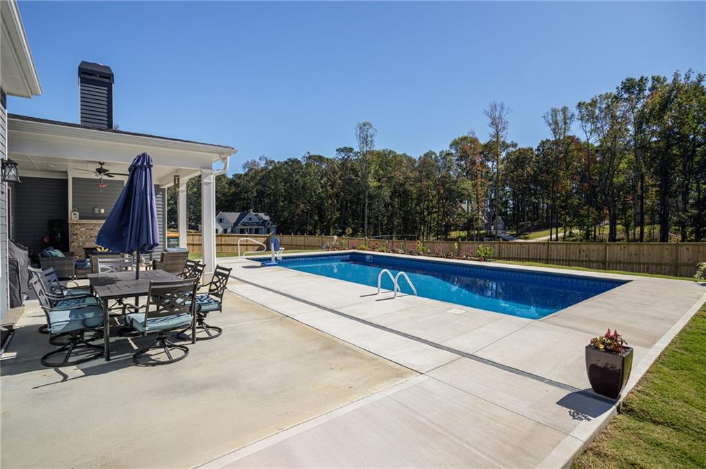 255 Old Town Road Dacula, GA 30019 - Photo 35 of 38 a view of swimming pool with outdoor seating and trees in the background