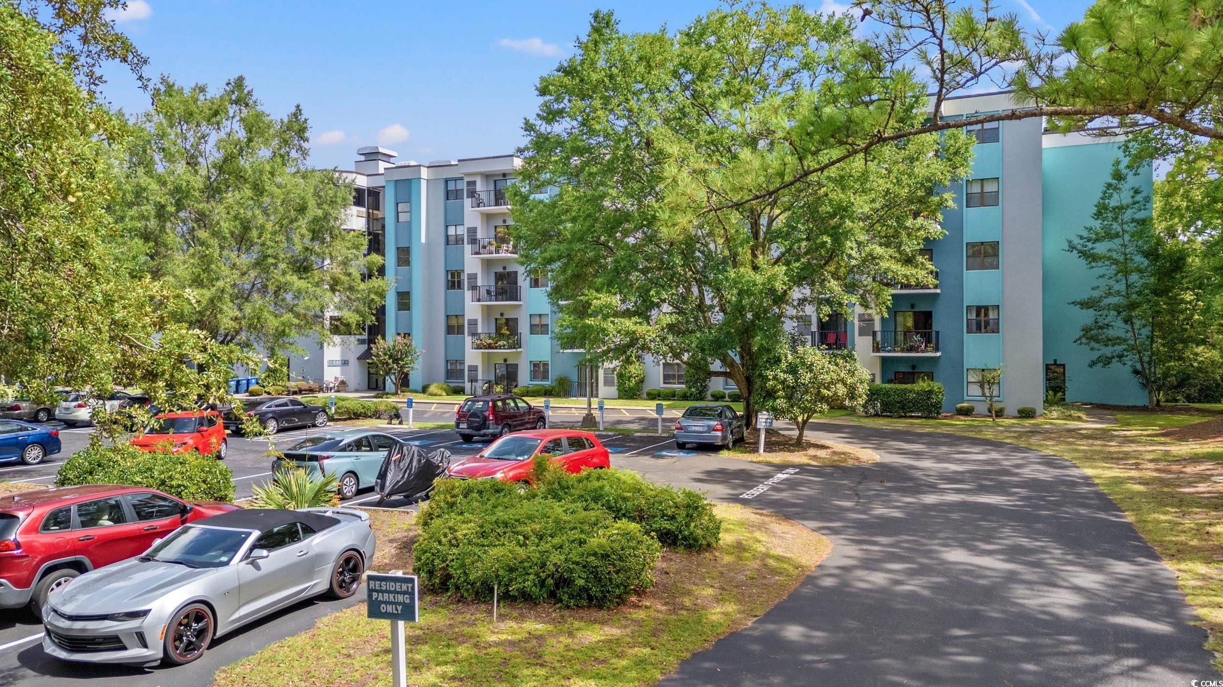 View of apartment building / complex featuring uncovered parking