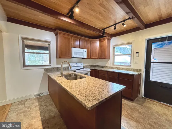 a kitchen with a stove sink and cabinets