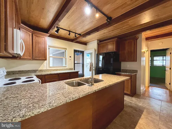 a kitchen with granite countertop sink and cabinets