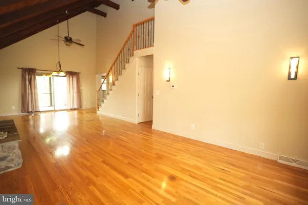 a view of empty room with wooden floor