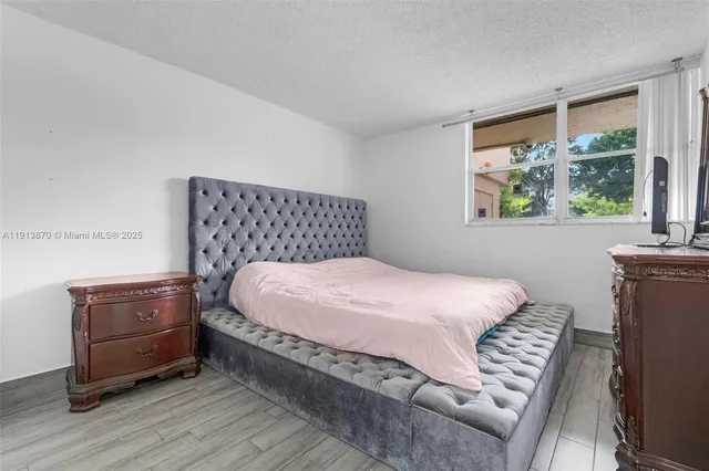 a view of grassy field with benches and trees all around