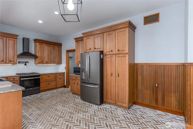 a kitchen with granite countertop a refrigerator stove top oven and sink