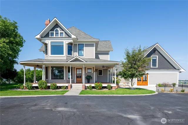 a front view of a house with a yard and potted plants