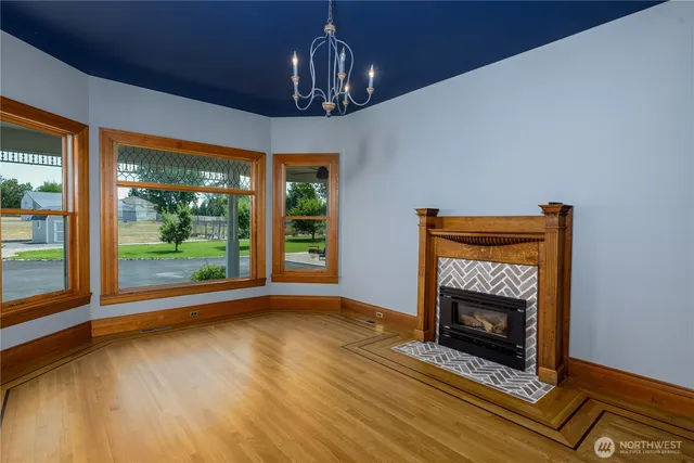 a view of empty room with wooden floor and fireplace