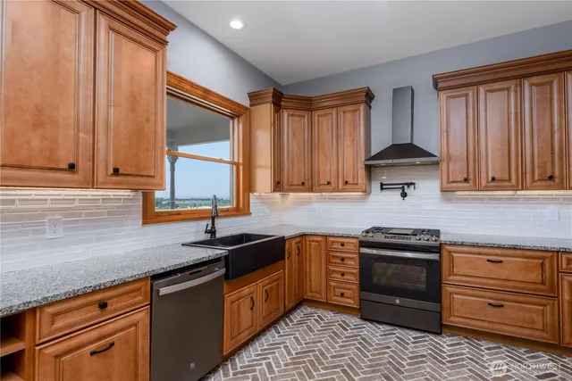 a kitchen with granite countertop a sink stainless steel appliances and cabinets