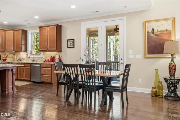 a view of a a dining room with furniture window and wooden floor