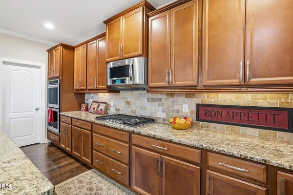 a kitchen with stainless steel appliances granite countertop a stove a sink and a microwave