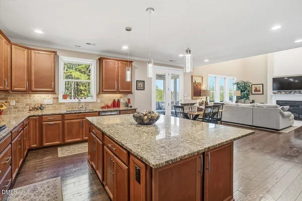 a kitchen with stainless steel appliances granite countertop a kitchen island a stove a sink a dining table and chairs